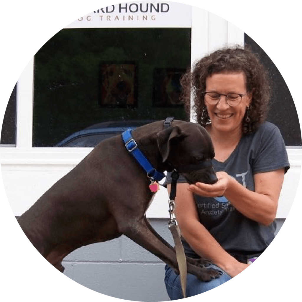 A CTC dog training graduate feeds her brown dog a treat