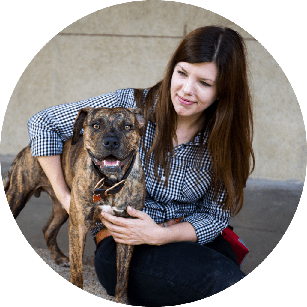 A dog training mentor poses alongside a smiling dog