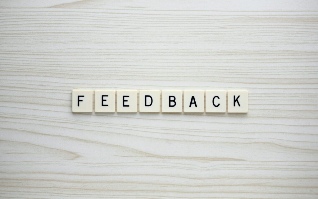 Feedback letter tiles on a wood grain background